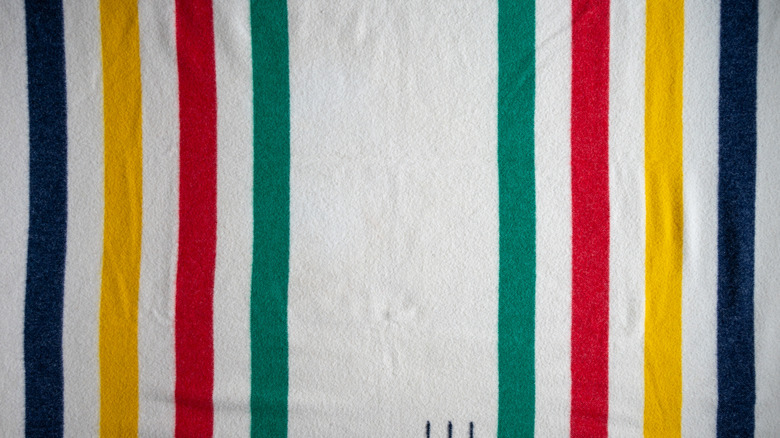 A Hudson Bay Point wool blanket with black, yellow, red, and green stripes