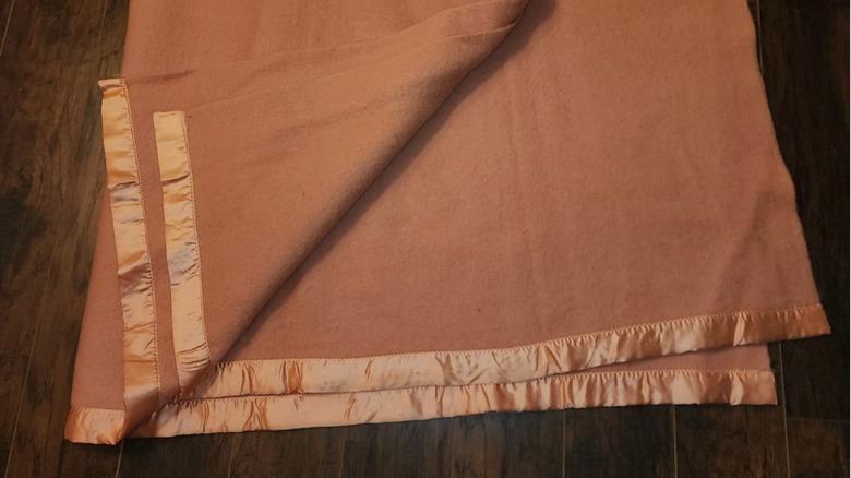 Rust-colored wool blanket with satin trim