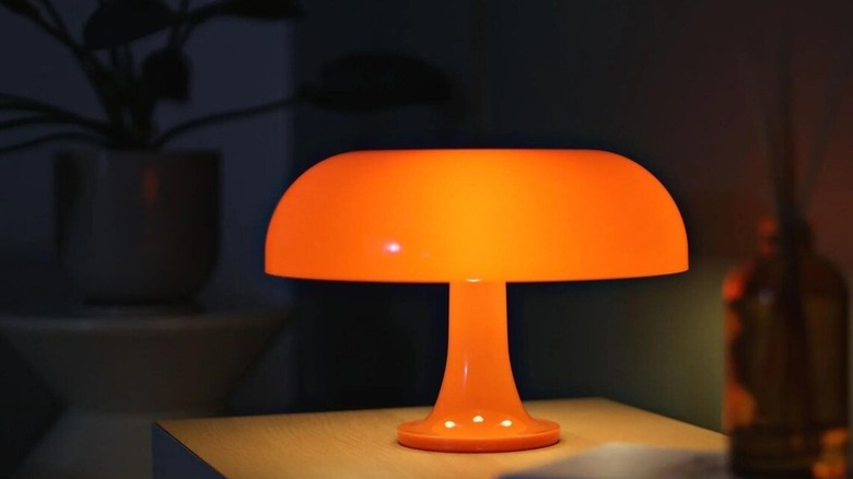 Orange Artemide mushroom style lamp in art deco style in dark room