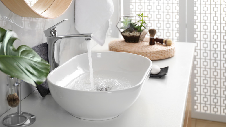 water running in vessel sink
