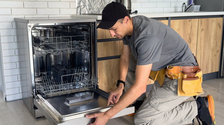 A technician in the process of repairing a dishwasher