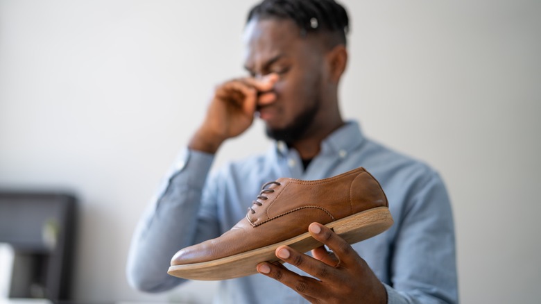 person holding stinky shoe