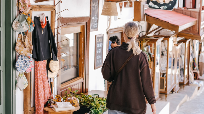 woman walking past a secondhand marketplace