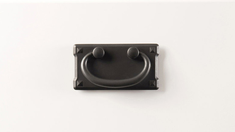 An iron vintage pull on a white drawer.