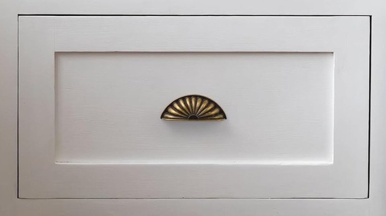 A vintage gold pull on a drawer.