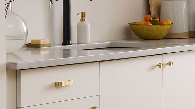 Cream cabinets with gold hardware.