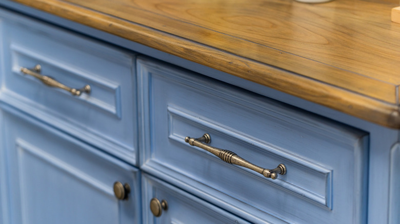 A blue cabinet with vintage-inspired pulls.