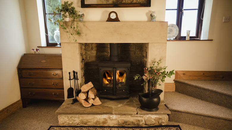 A beautiful interior shot of a fire place with a real log fire burning.