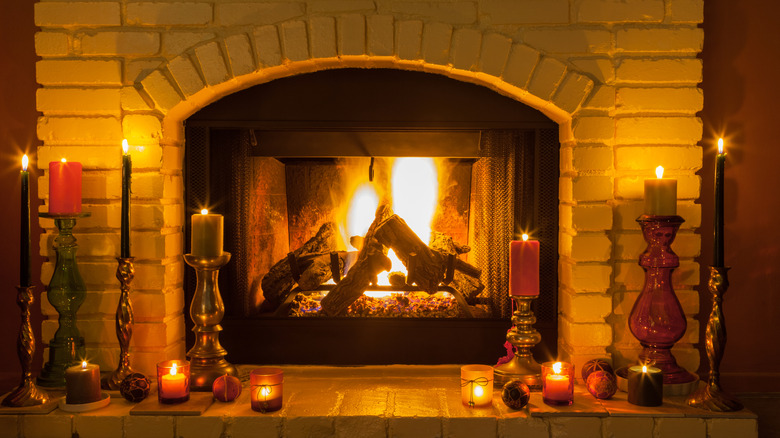A cozy old fashioned brick fireplace burns and is surrounded by candles for a romantic setting, for anytime of the year.