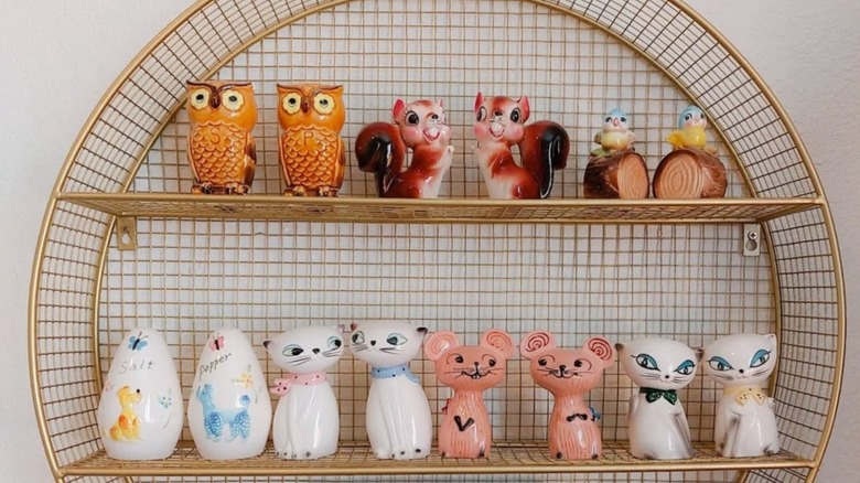 Many salt and pepper shakers are on a shelf.