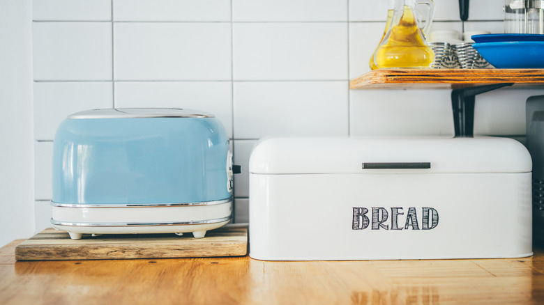 A vintage toaster and a breadbox on a counter