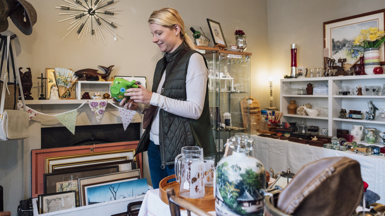 A woman shopping through vintage glass items