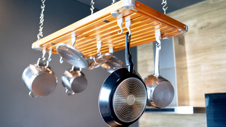 hanging pot rack with pots and pans attached to hooks
