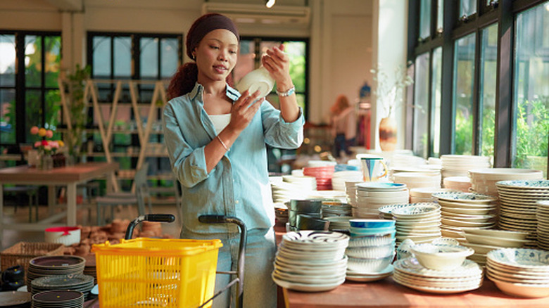Someone shopping for dishware at the thrift store