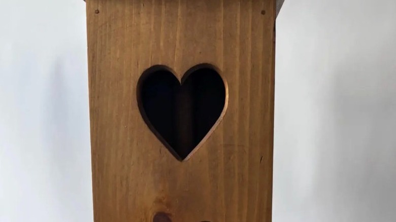 The top half of a vintage wooden toilet paper holder