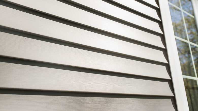 Sun shining on new, grey vinyl siding.