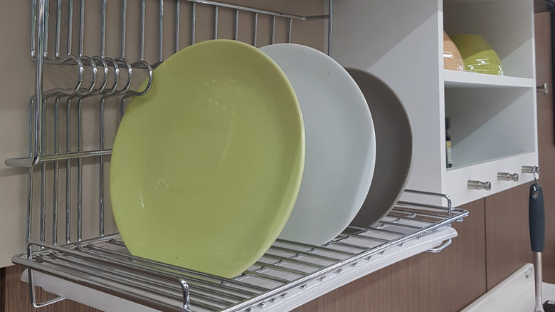 Three plates in a wall mounted dish drying rack