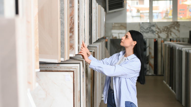 Woman browsing bathroom material samples at a showroom