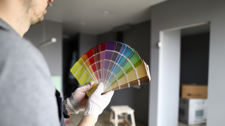 A man holding paint swatches