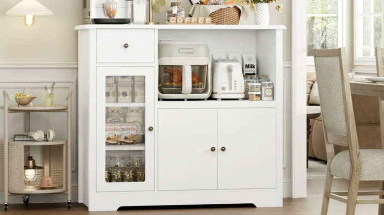 A storage cabinet holding pantry items and small appliances