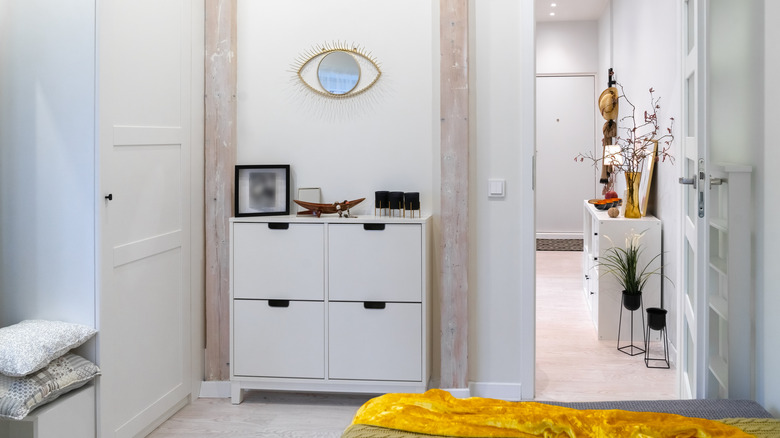 A simple white storage cabinet in a bedroom