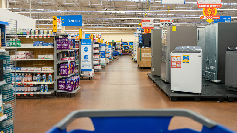 A blue shopping cart is pushed through the aisles at Walmart