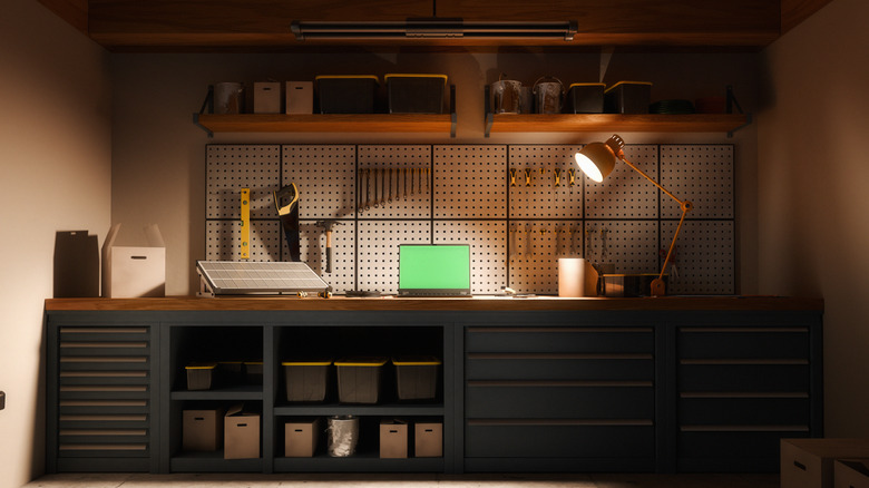 Workshop space in garage with laptop, lamp, and storage containers