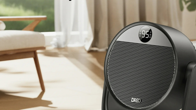 A DREO Space Heater sits on a wooden side table in a neutral living room