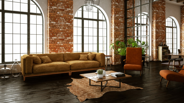 Industrial interior with brick walls, cozy chairs, and plants