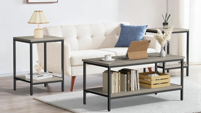 A modern living room with a white sofa and three industrial style tables