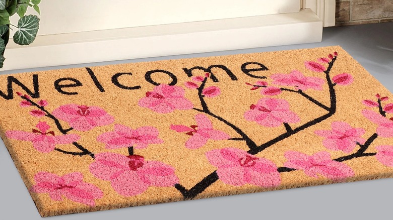 Closeup of a floral doormat with welcome text