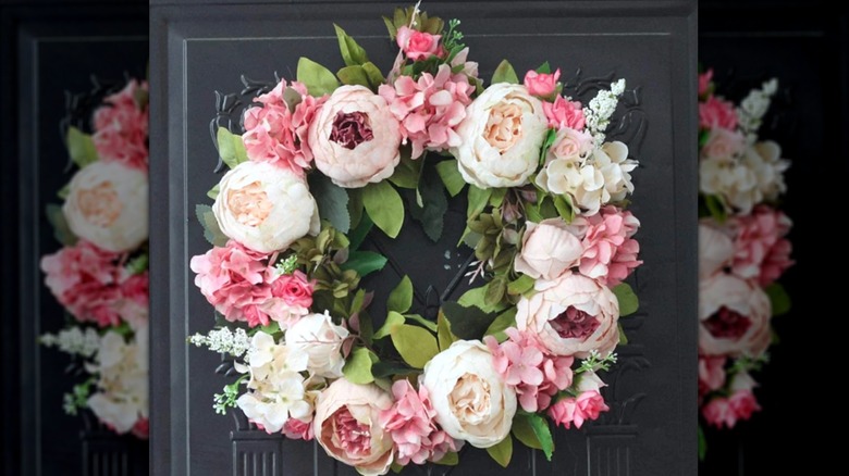 Closeup of a peony wreath hanging on a door