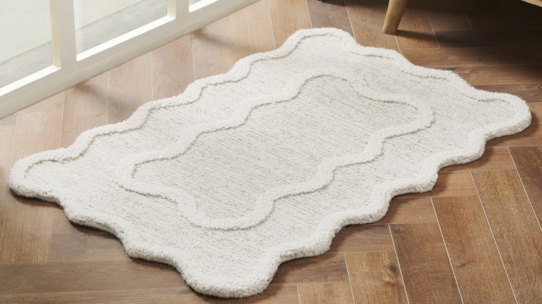Ivory scallop-shaped rug on a wood floor