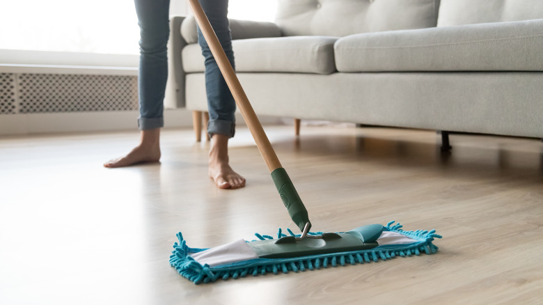 A dry mop being used to clean wood flooring