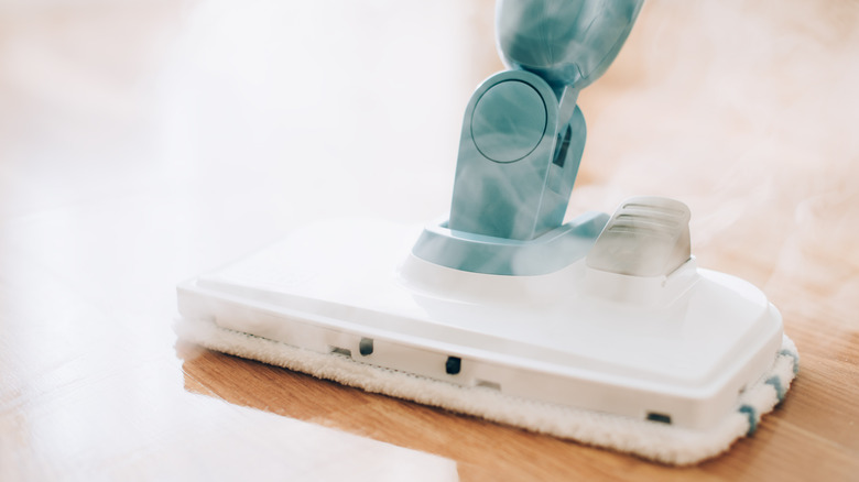 A steam mop cleaning wood flooring