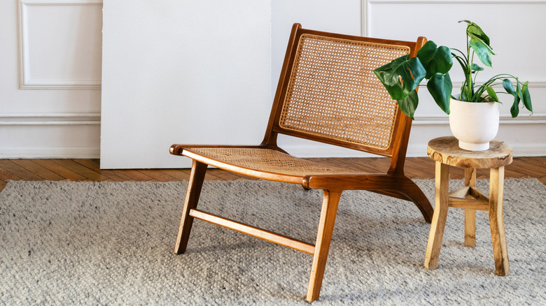 Vintage rattan chair with wood side table and rug
