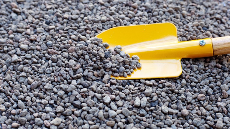 Close up of yellow shovel holding pumice rocks