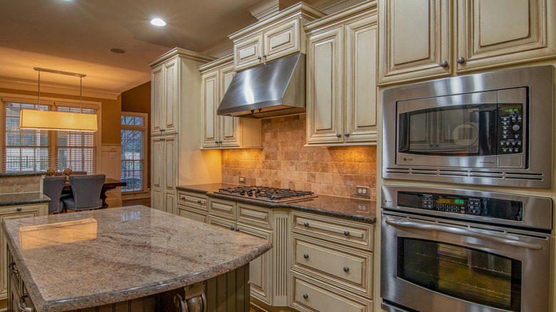 White birch cabinets in kitchen with stainless steel appliances