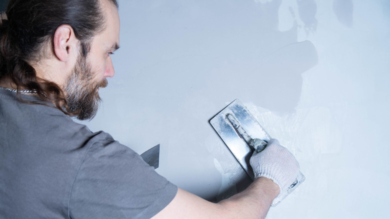 Man applying a microcement coating to a wall