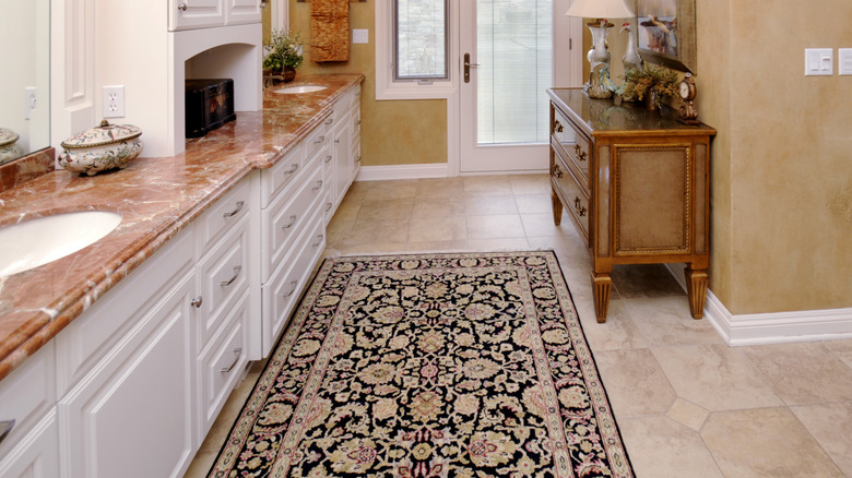 Rug on brown tiled bathroom floor