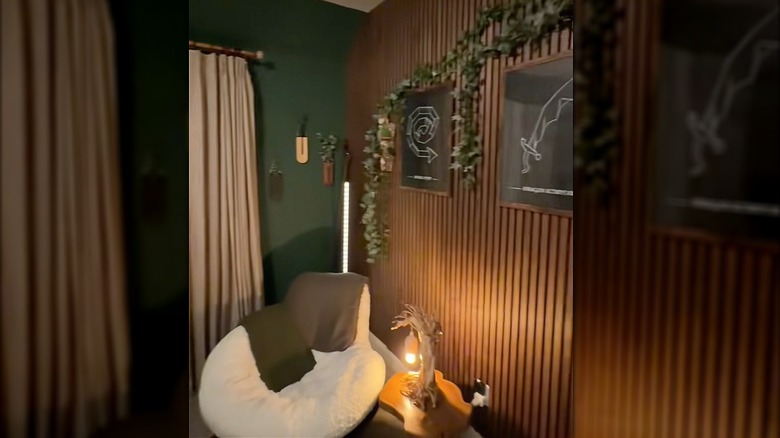Room with soft lounge chair, custom art, plants, and wood accents