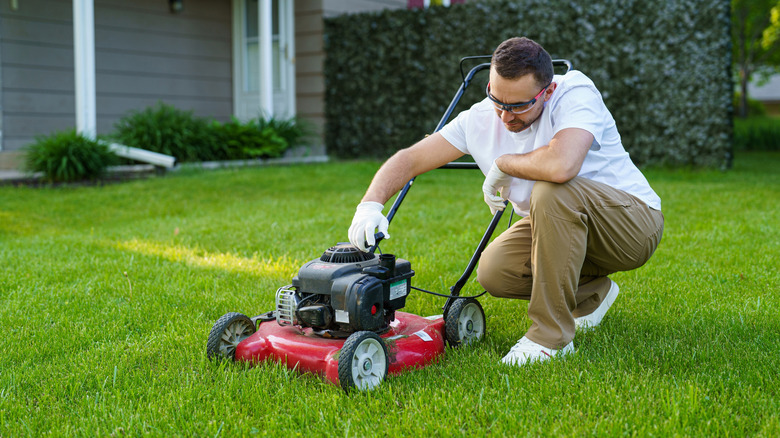Man repairing lawn mower