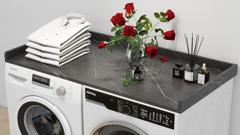 Black marble washer and dryer countertop topped with flowers.