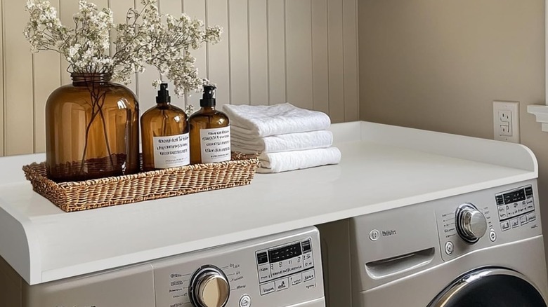 White washer and dryer countertop decorated with basket and towels.
