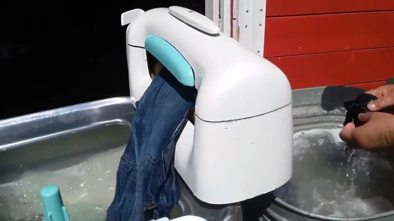 A demonstration of a wringer-style washer in use