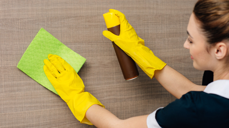 persona che spruzza il detergente