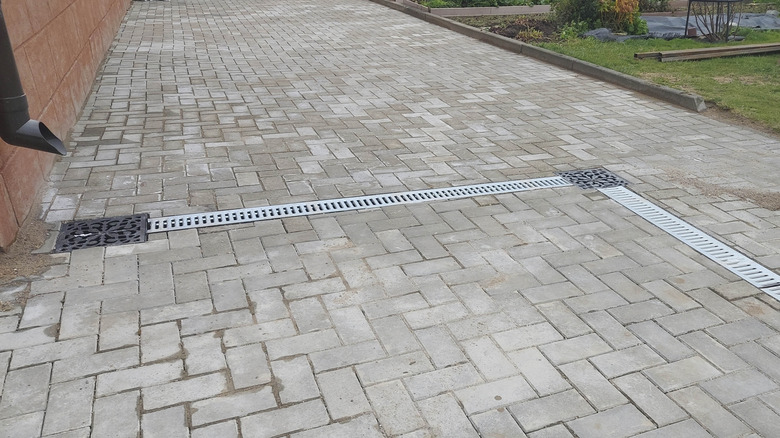 A paved driveway with trench drains running through the middle of it.
