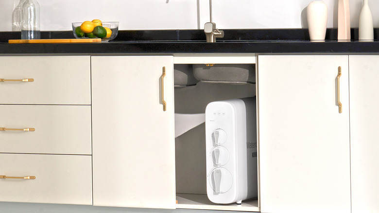 A white Waterdrop Filter brand system stored in a white cabinet