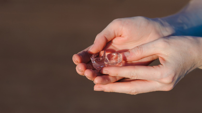 person holding two ice cubes