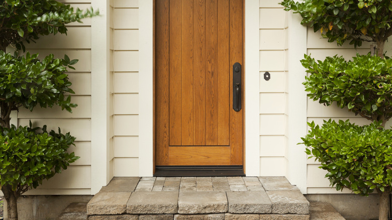 Decorative trees flanking entrance steps and doorway